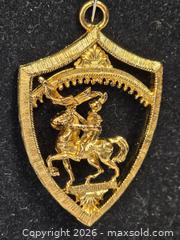 MaxSold Auction: gold-tone metal pendant or brooch featuring a warrior on horseback within a shield design. - Toronto (Ontario, Canada) SELLER MANAGED Reseller Online Auction - Dartmoor Drive