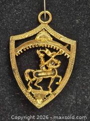 MaxSold Auction: gold-tone metal pendant or brooch featuring a warrior on horseback within a shield design. - Toronto (Ontario, Canada) SELLER MANAGED Reseller Online Auction - Dartmoor Drive