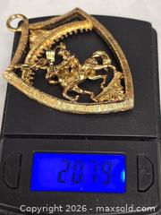 MaxSold Auction: gold-tone metal pendant or brooch featuring a warrior on horseback within a shield design. - Toronto (Ontario, Canada) SELLER MANAGED Reseller Online Auction - Dartmoor Drive